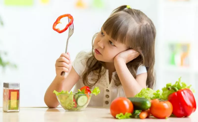 بشقاب رنگارنگ غذاهای سالم برای کودکان در حال خوردن